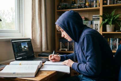 Adolescent étudiant le game design tout en révisant les mathématiques sur son bureau à la maison