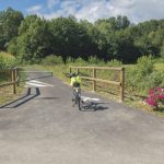 a person riding a bike across a bridge